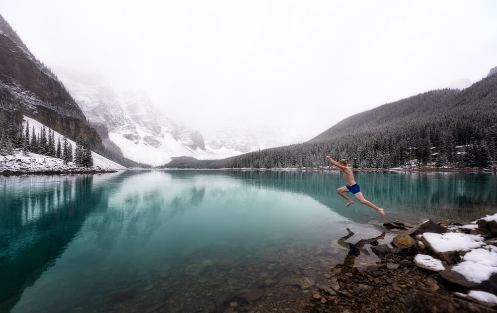 Man jumping into a lake in winter